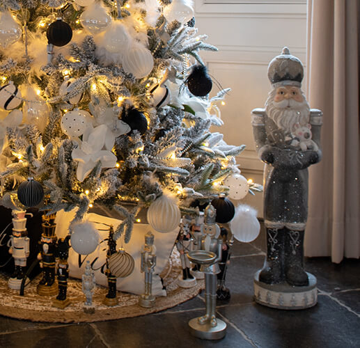 Weißer und silberner Weihnachtsbaum mit einer Santa Claus-Figur.