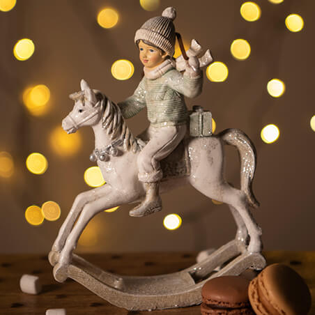 Figurine of a boy on a rocking horse.