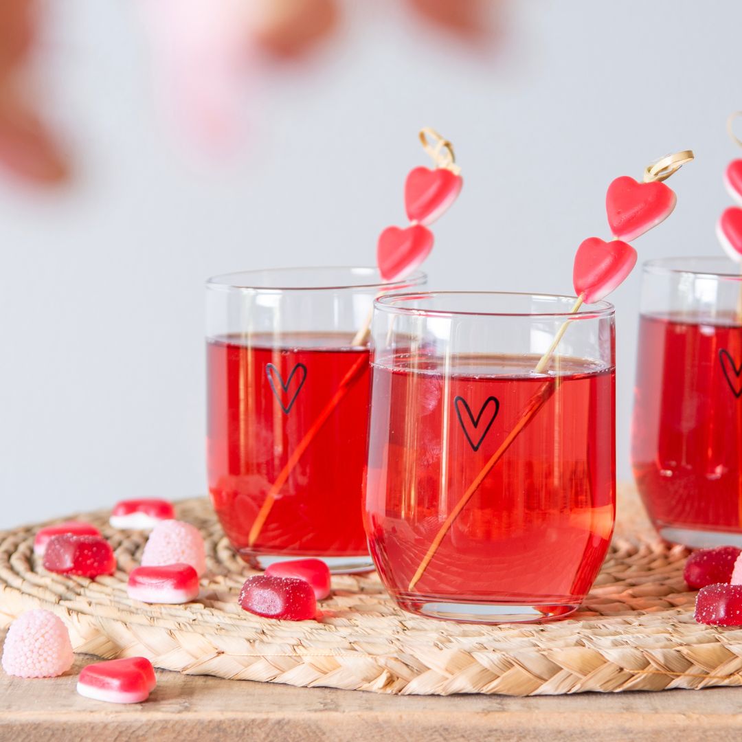 Glazen vaas en glazen fles met roze bloemen