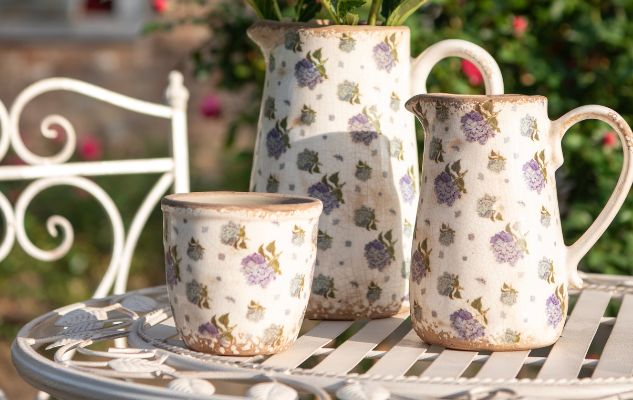 Kannen en één bloempot met een bloemenmotief geplaatst op een bistroset