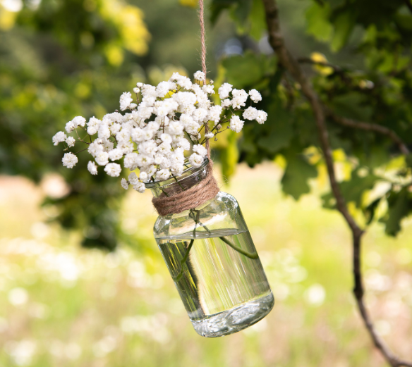 Glazen vaas en glazen fles met roze bloemen