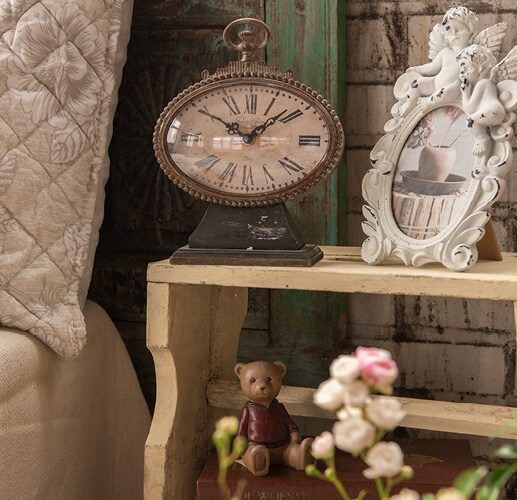 Clock and photo frame on a nightstand.