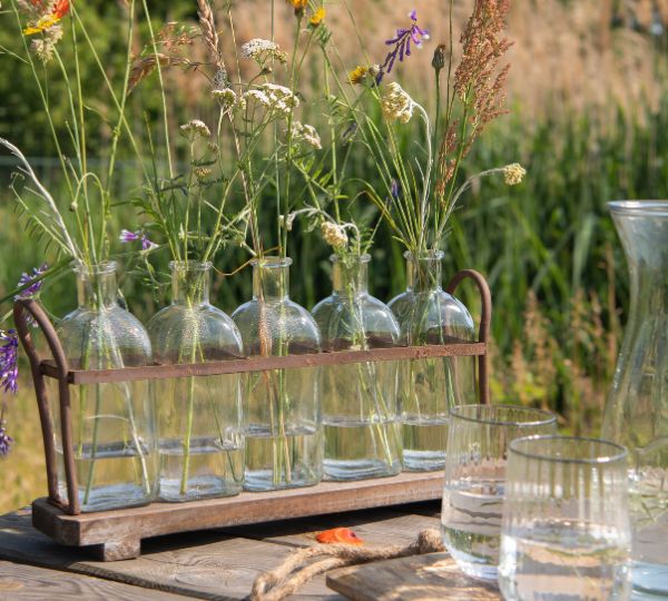 Plantenhouder Kleine doorzichtige vaasjes gevuld met bloemen.