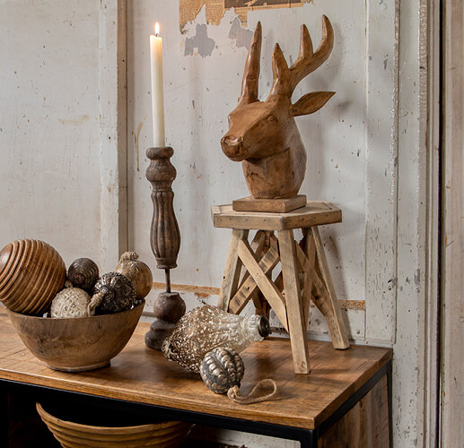 Wooden deer sculpture on a stool.