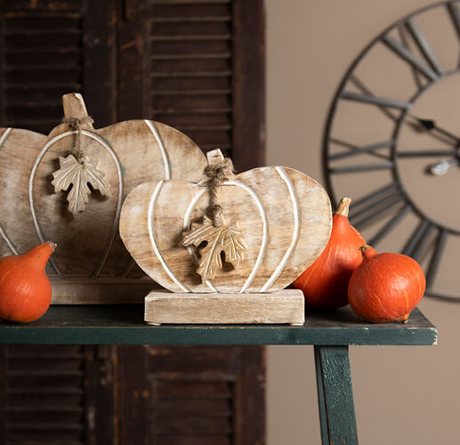 Citrouilles en bois et vraies citrouilles.