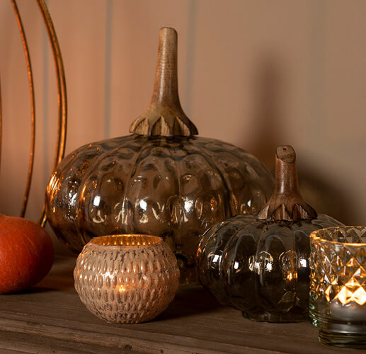 Citrouilles en verre avec quelques porte-bougies.