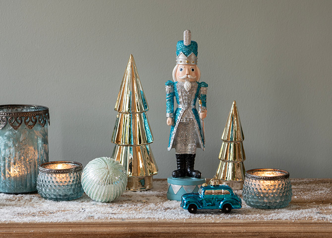 Blue and gold Christmas decoration featuring Christmas trees, Christmas balls, nutcracker, and tealight holders