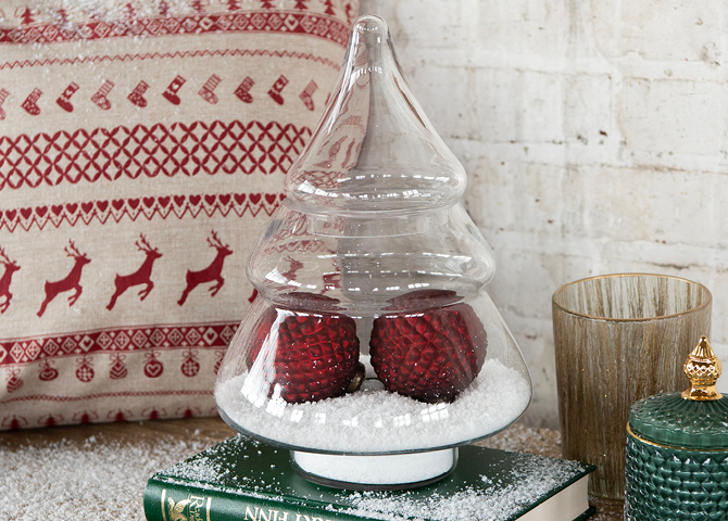glazen stolp in de vorm van een kerstboom met rode kerstballen en nepsneeuw