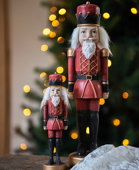 Rote Nussknacker mit Weihnachtsbeleuchtung im Hintergrund