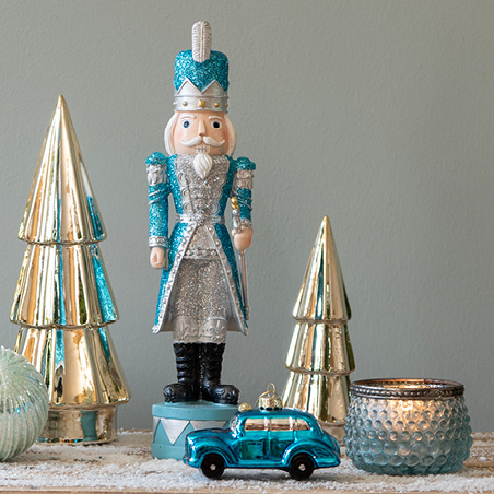 Blue Christmas trend with a blue nutcracker and golden Christmas trees
