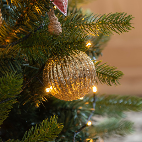 Boule de Noël dorée dans un sapin artificiel