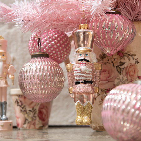 Décoration de Noël rose avec des boules de Noël roses et un casse-noisette