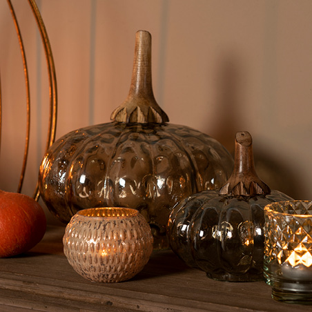 Two glass pumpkins with a tealight holder