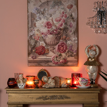 Gold-colored mantelpiece with home decor and a painting as the centerpiece