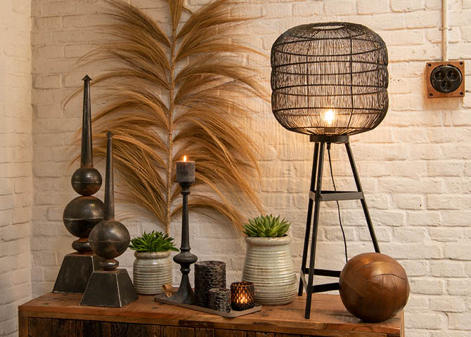 Flower pots, burning candles, a candleholder, a lamp, and a ball in an industrial style.