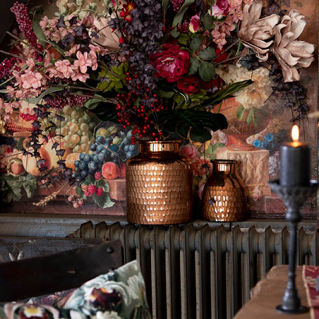 Un coussin, des pots de fleurs et de la décoration murale.