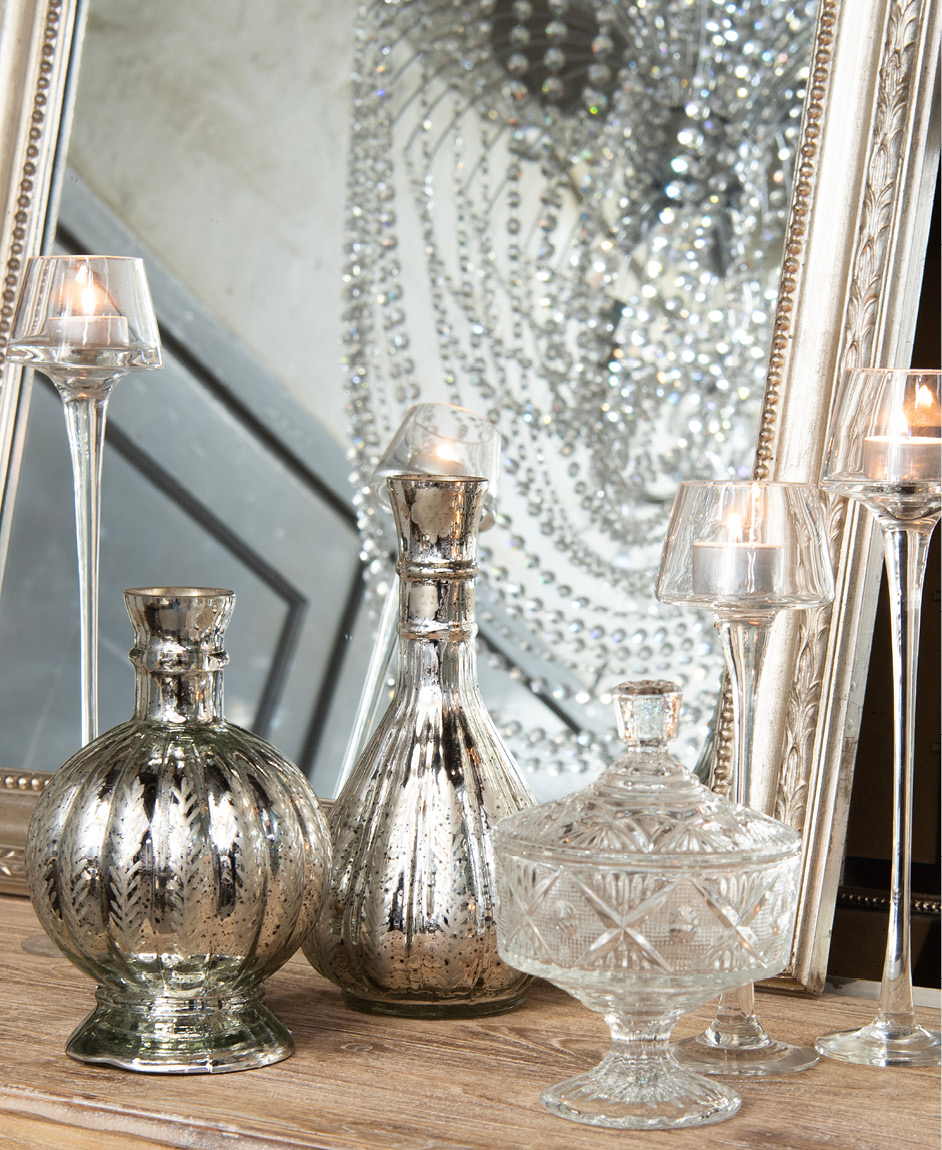 Glass boxes and candleholders with burning candles in a classic style.