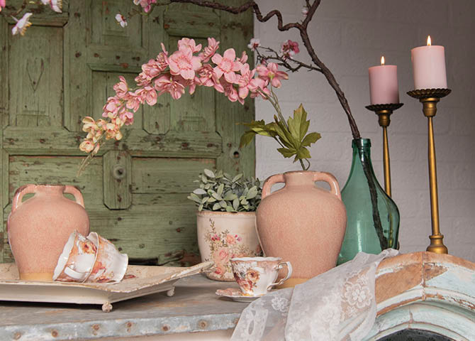 Des bougeoirs, des pots de fleurs, des carafes, des tasses à thé et une assiette.