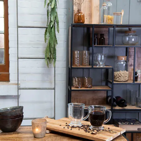 Ein Schrank mit Glasbehältern, Teetassen, Schalen, einem Brotbrett, einem Handtuchhalter und einer Kerze im industriellen Stil.