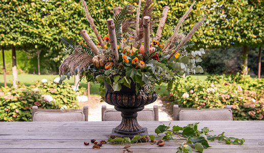 Un vase décoré de fleurs artificielles et de branches
