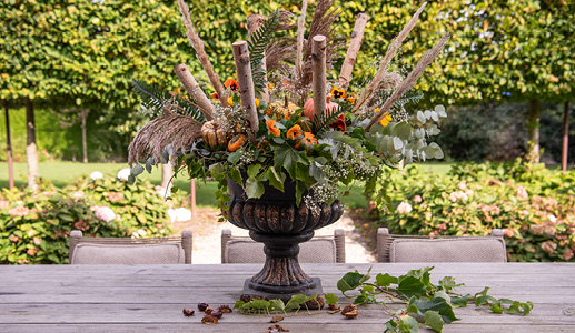 Een vaas die is opgemaakt met kunstbloemen en takken