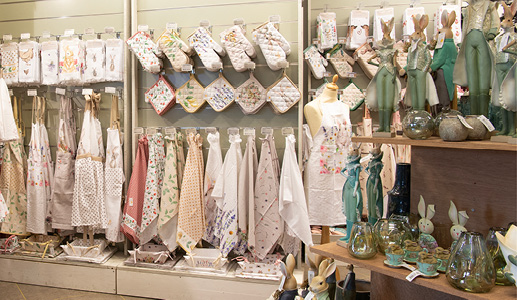 A store display of tea towels, oven gloves, pot holders, guest towels, and aprons