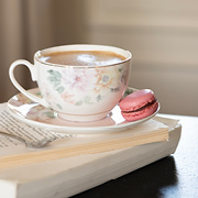 Een vintage kop en schotel met een roze macaron