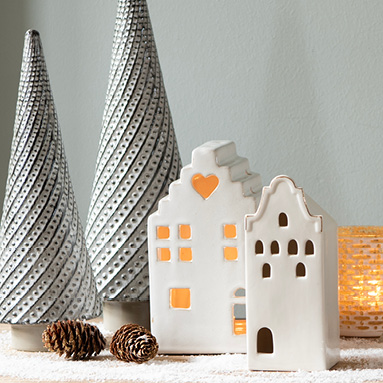 Two white ceramic decorative houses and two gray decorative Christmas trees