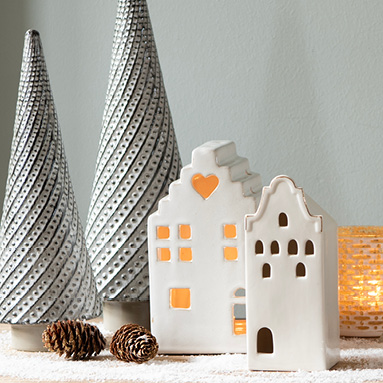 Twee witte keramieken decoratiehuisjes en twee grijze decoratie kerstboompjes