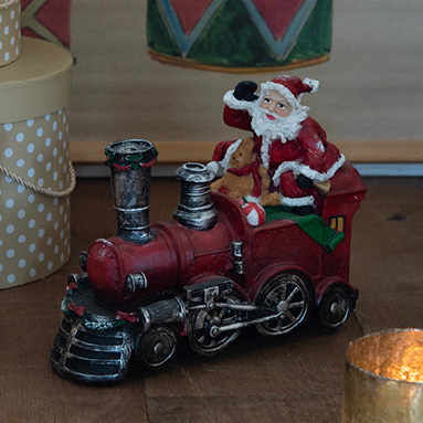 Een rode kerstman in een rode locomotief