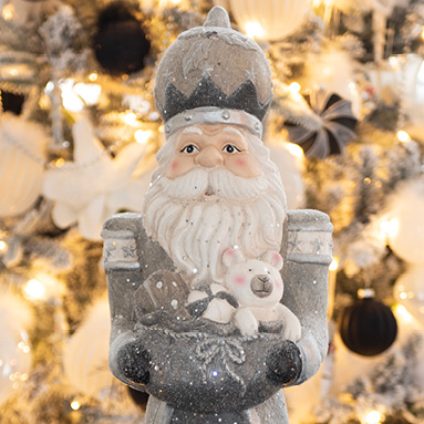 A Santa Claus in gray attire carrying a sack of toys