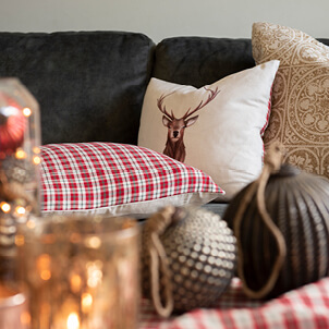 A decorative pillow with a deer and a checkered pattern