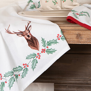A white tea towel with a deer and Christmas holly