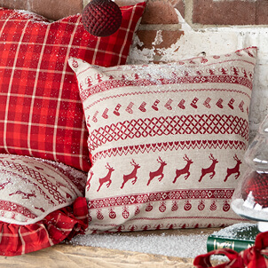 A decorative pillow with a classic Christmas pattern in beige and red colors