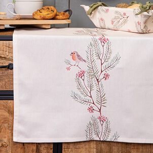 A white table runner with a robin and green branches
