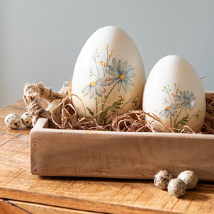 A wooden tray with two spring decorative eggs in it