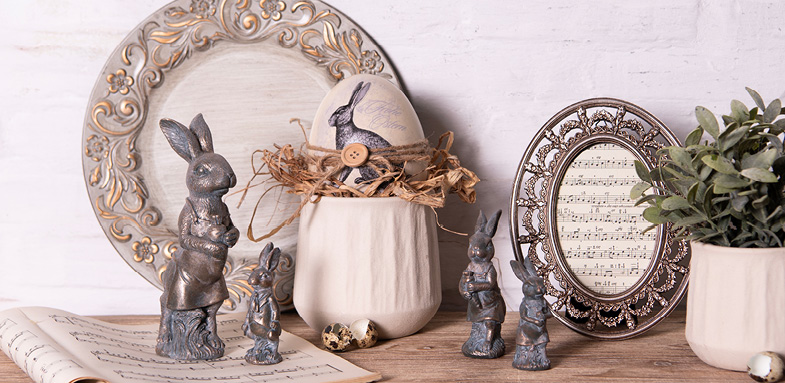 Rustic Easter decoration with photo frames, flower pots, silver rabbit statues, and decorative eggs