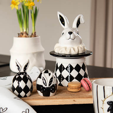 Rustieke paasdecoratie met fotolijsten, bloempotten, zilverkleurige konijnen beelden en decoratie ei