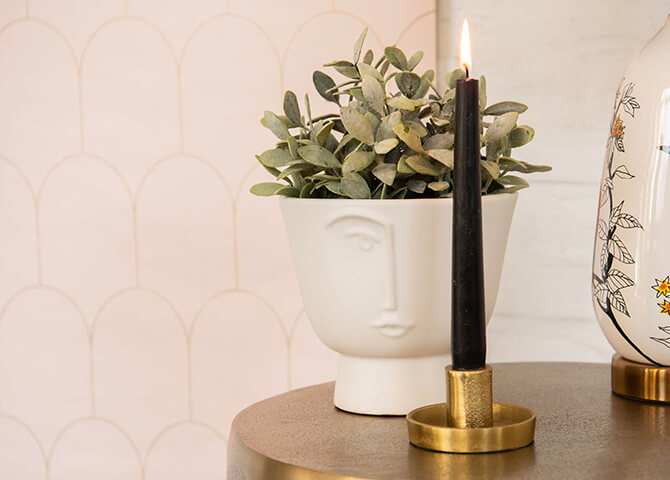 A modern flower pot and a gold-colored minimalist candle holder are great accessories for a modern interior