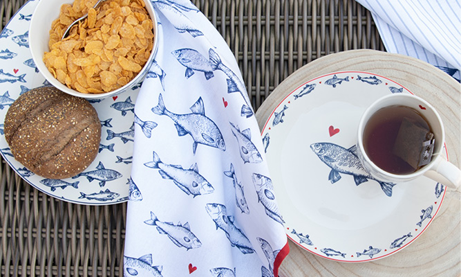 Plates and a tea towel with a maritime fish pattern