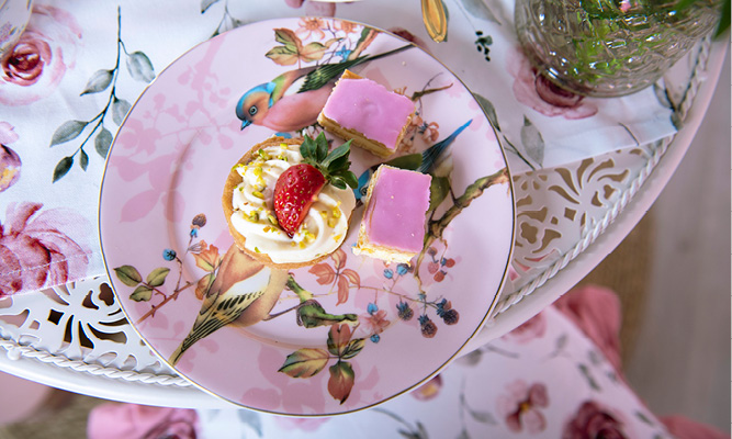 Ein romantischer rosa Dessertteller mit niedlichen Vögeln und Tompouzen (Blätterteiggebäck mit Creme)