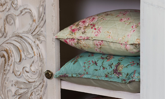 Two country-style cushions in a shabby chic storage cabinet