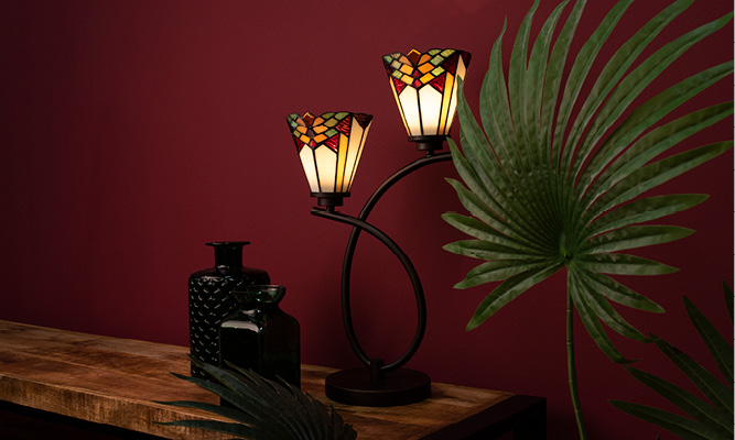 A vintage Tiffany table lamp in Art Deco style with green vases and a red background