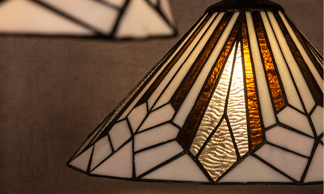 Una lampada a sospensione Tiffany in stile Art Deco con elementi bianchi e marroni