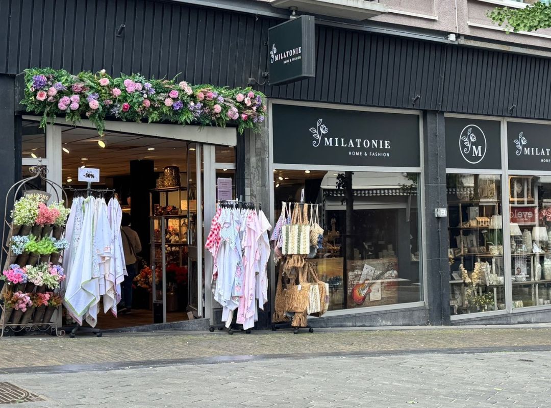 The Milatonie store in Nijmegen stands out with a colorful flower arch and a varied selection of textiles, bags, and home accessories. Inside, a warm and inviting atmosphere awaits.