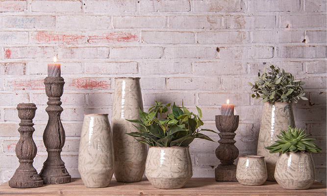 Un style d'intérieur rural avec des vases verts et des pots de fleurs, ainsi que des bougeoirs en bois