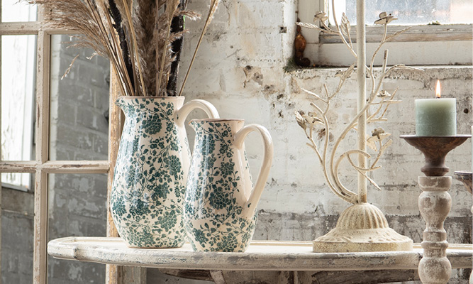 Two shabby chic pitchers with dried flowers inside