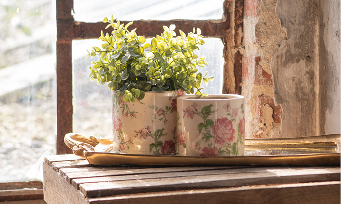 Twee romantische bloempotten met pioenrozen erop en ze staan op een goudkleurige dienblad