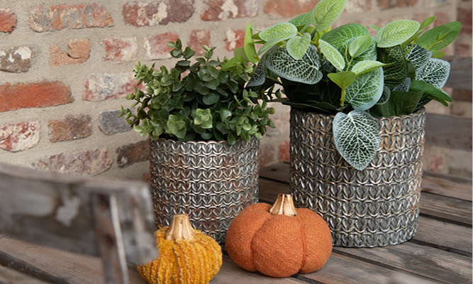 Two industrial-style flower pots with fabric decorative pumpkins