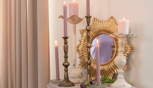 Bougies dorées et blanches dans un style romantique avec des bougies de dîner violet pastel et un miroir mural doré